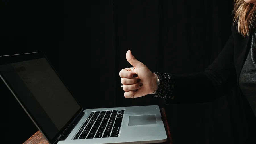 Eine Frau zeigt am Laptop den Daumen nach oben