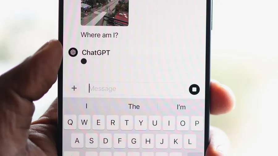 Hand hält ein Smartphone mit geöffneter ChatGPT-App, oben ein geteiltes Foto, darunter die Bildschirmtastatur