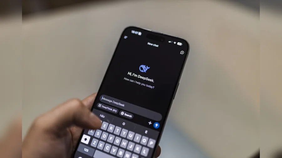 Eine Hand hält ein Smartphone, auf dem die Chat-App von DeepSeek geöffnet ist