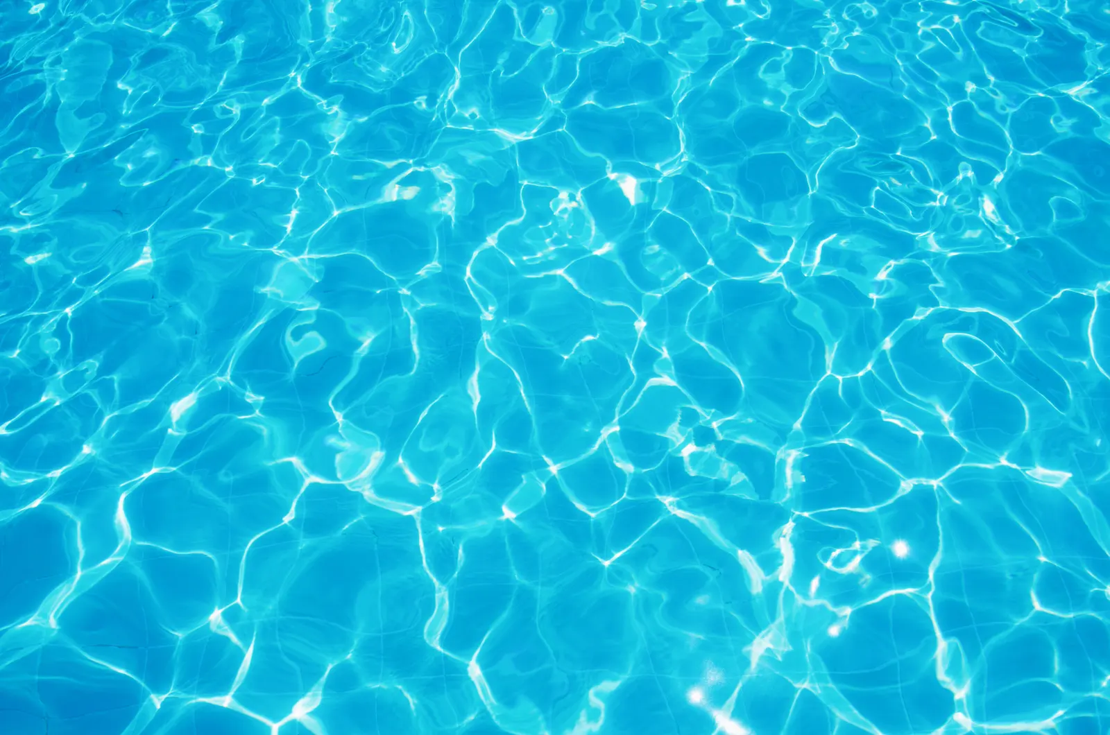 Sonnenlicht bricht sich auf der Wasseroberfläche eines Pools.